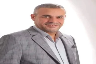 قبل أن تتجاوزنا الآلة: صورة لرجل أردني يرتدي سترة رسمية يناقش المستقبل الرقمي والذكاء الاصطناعي.