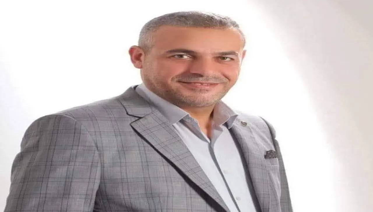 قبل أن تتجاوزنا الآلة: صورة لرجل أردني يرتدي سترة رسمية يناقش المستقبل الرقمي والذكاء الاصطناعي.
