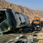حافلة ركاب بيضاء منقلبة على جانبها في منطقة جبلية بطريق دهب نويبع بوجود سيارات الإسعاف