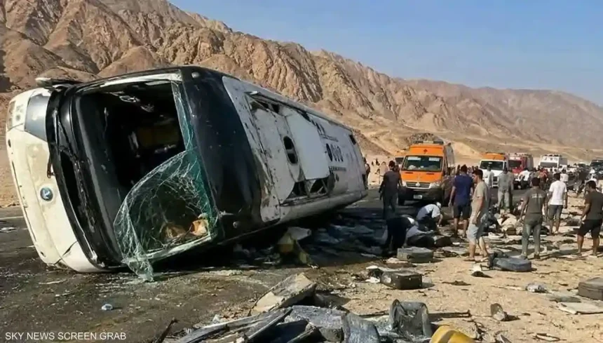 حافلة ركاب بيضاء منقلبة على جانبها في منطقة جبلية بطريق دهب نويبع بوجود سيارات الإسعاف