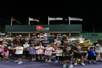 صورة جماعية للفائزين والمشاركين في بطولة الأردن المفتوحة الثانية للتنس يحملون الكؤوس والمضارب في ملعب الاتحاد الأردني للتنس.