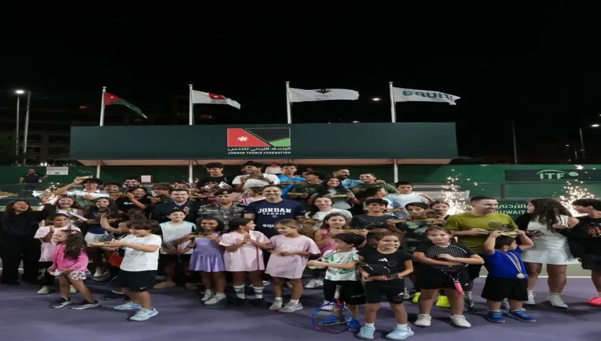 صورة جماعية للفائزين والمشاركين في بطولة الأردن المفتوحة الثانية للتنس يحملون الكؤوس والمضارب في ملعب الاتحاد الأردني للتنس.