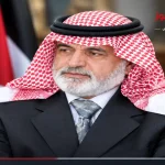 صورة بورتريه للسياسي والكاتب الأردني سالم الفلاحات يرتدي الكوفية والشماغ الأحمر والأصفر أمام العلم الأردني.