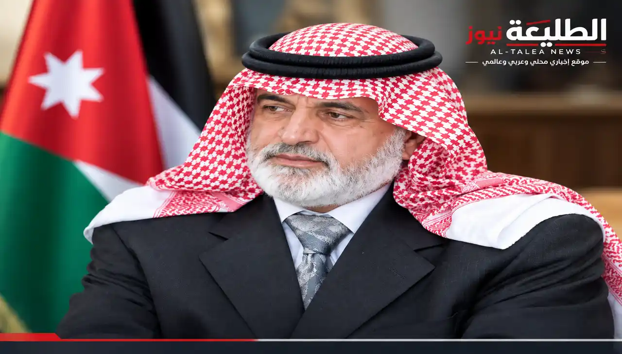 صورة بورتريه للسياسي والكاتب الأردني سالم الفلاحات يرتدي الكوفية والشماغ الأحمر والأصفر أمام العلم الأردني.