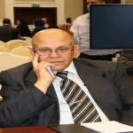 صورة صحفية للكاتب عناد أبو وندي جساً في مؤتمر إعلامي، مع شاشة في الزاوية تعرض شعار "الطليعة نيوز" وعنوان "الصحفي يصنع مصداقية" ونص "بقلم الكاتب عناد أبو وندي". يظهر في المقدمة ميكروفون يحمل شعار "الطليعة".