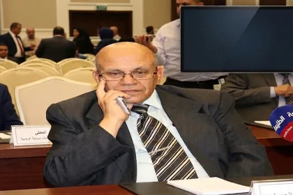 صورة صحفية للكاتب عناد أبو وندي جساً في مؤتمر إعلامي، مع شاشة في الزاوية تعرض شعار "الطليعة نيوز" وعنوان "الصحفي يصنع مصداقية" ونص "بقلم الكاتب عناد أبو وندي". يظهر في المقدمة ميكروفون يحمل شعار "الطليعة".