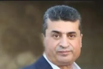 محافظ العقبة أيمن العوايشة يرتدي بدلة رسمية.