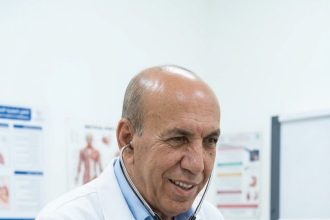 طبيب يفحص مريضاً بالسماعة للتعبير عن فكرة جس نبض العلاقات دائماً في الحياة والسياسة والمجتمع.