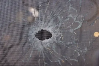هجوم كنيسة قرية حمود يظهر ثقب رصاصة في زجاج النافذة مع تشققات زجاجية بعد إطلاق النار في الكرك اليوم.