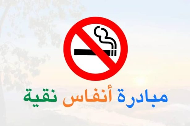 أنفاس نقية في عجلون شعار مبادرة المعلم محمد المومني لمكافحة التدخين مع رمز ممنوع التدخين على خلفية سماء