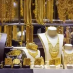 واجهة محل مجوهرات فاخر يعرض قلائد وتيجان وأساور ذهب خليجي بتصاميم تراثية راقية ومميزة للعروس الخليجي 100 حرف بالضبط - يتضمن الكلمة المفتاحية