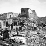 مجزرة قرية قبية 1953 صورة تاريخية لجثامين الشهداء على الأرض ومنازل مدمرة ونساء فلسطينيات يبكين