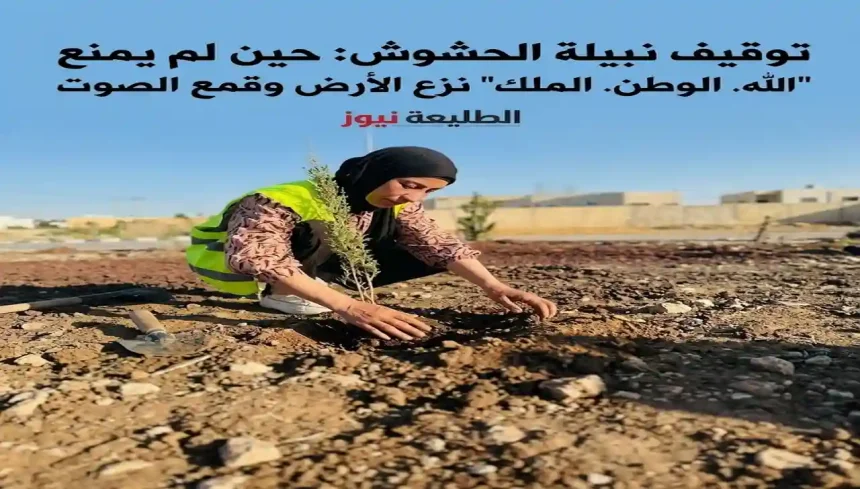 امرأة بحجاب وسترة أمان تزرع شتلة في أرض جافة، مجرفة بجانبها.